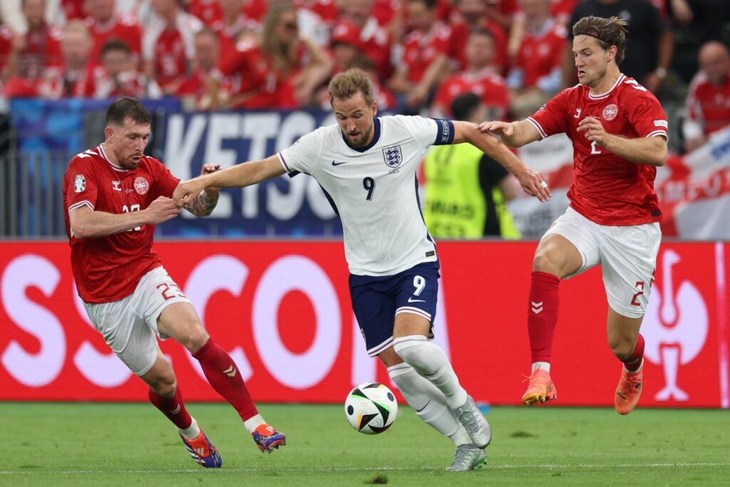 Der englische Stürmer #09 Harry Kane (C), der dänische Mittelfeldspieler #23 Pierre-Emile Hojbjerg und der dänische Verteidiger #02 Joachim Andersen kämpfen um den Ball während des Fußballspiels der UEFA Euro 2024 Gruppe C zwischen Dänemark und England in der Frankfurt Arena in Frankfurt am Main am 20. Juni 2024. (Foto: Adrian DENNIS / AFP)