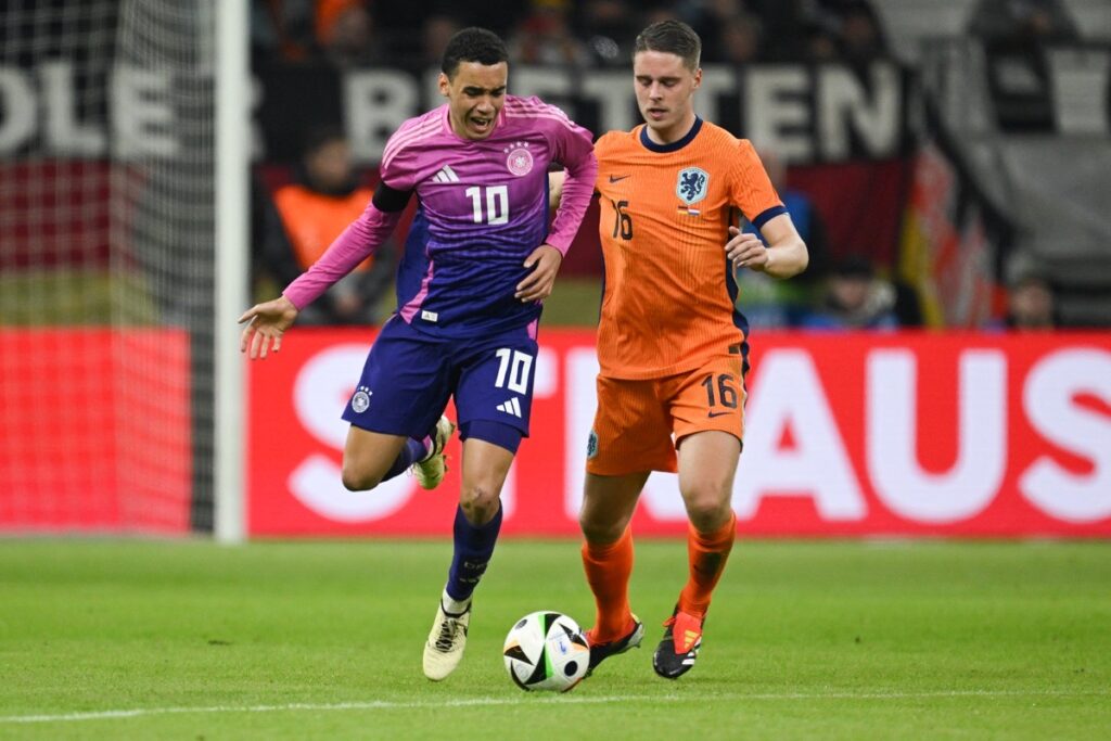 Der deutsche Mittelfeldspieler Nr. 10 Jamal Musiala (links) gegen den niederländischen Mittelfeldspieler Nr. 16 Joey Veerman während des Freundschaftsspiels zwischen Deutschland und den Niederlanden am 26. März 2024 in Frankfurt am Main um den Ball kämpft. (Foto: INA FASSBENDER / AFP)