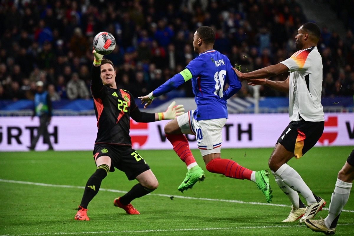 Der deutsche Torwart Nr. 22 Marc-Andre Ter Stegen (links) hält einen Schuss des französischen Stürmers Nr. 10 Kylian Mbappe (Mitte) während des Freundschaftsspiels zwischen Frankreich und Deutschland im Groupama-Stadion in Decines-Charpieu bei Lyon am 23. März 2024. (Foto: Olivier CHASSIGNOLE / AFP)